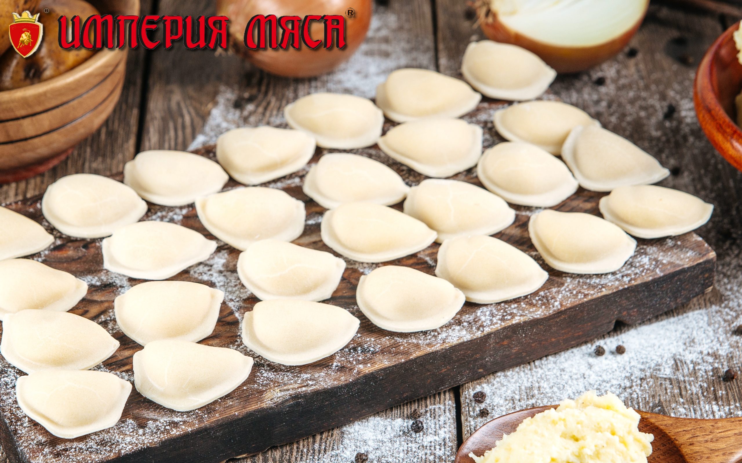 Side view on raw uncooked semi-finished small vareniki dumplings with a filling on a wooden board on a table, horizontal format